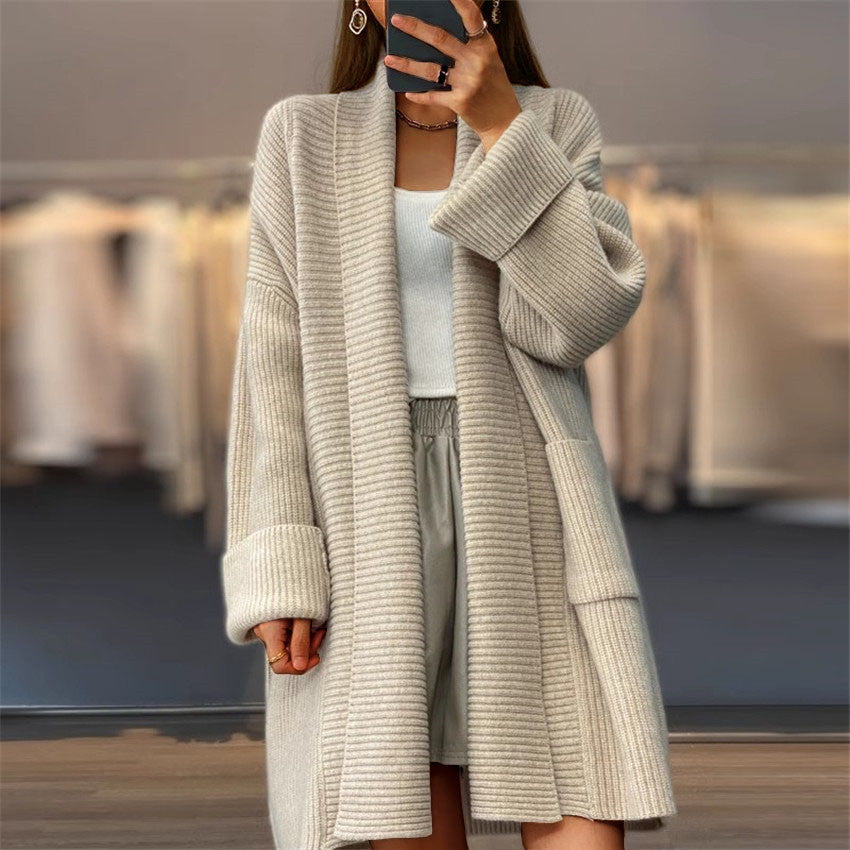 Cardigan tricoté unicolore à poches amples, style manteau-pull.