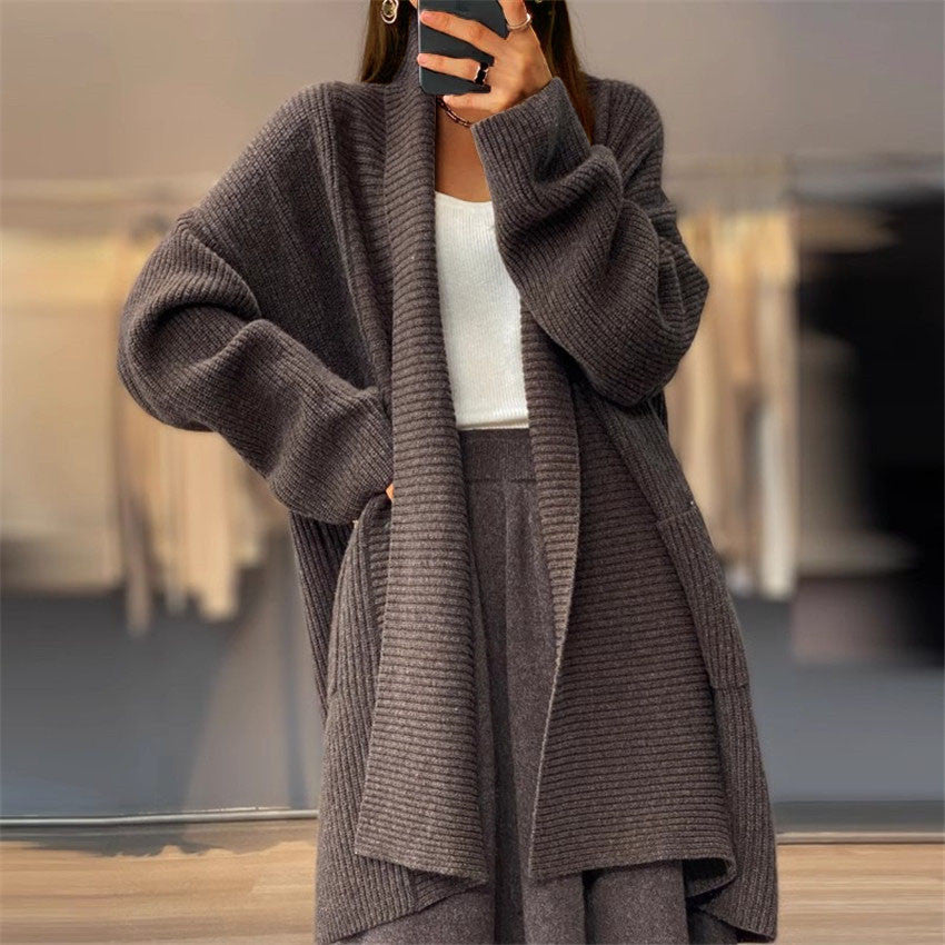 Cardigan tricoté unicolore à poches amples, style manteau-pull.